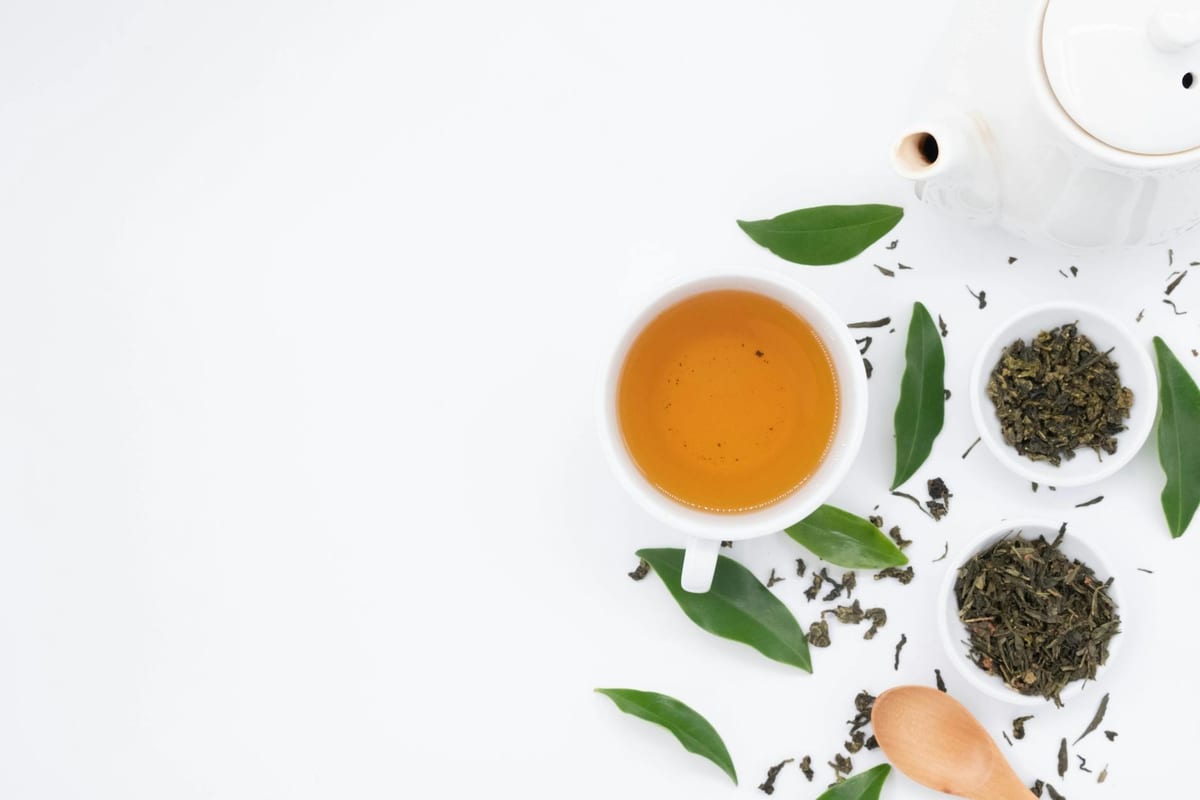 cup of green tea with loose leaves