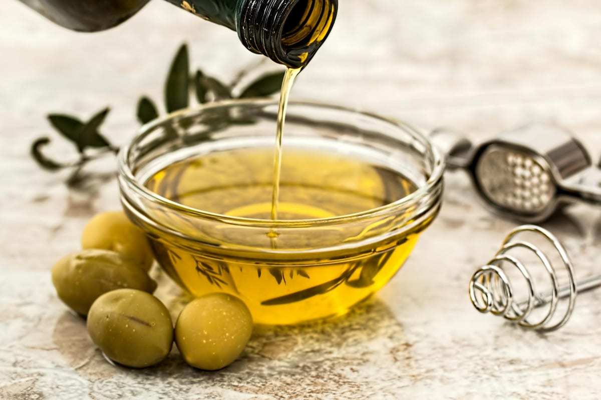 olive oil pouring with fresh olives